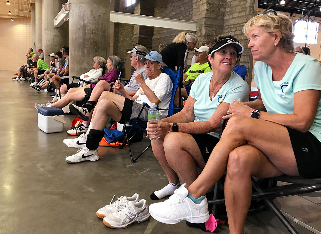 Pickleball teammates Susie Burton, left, and Nancy Scanlan rest alongside the courts
